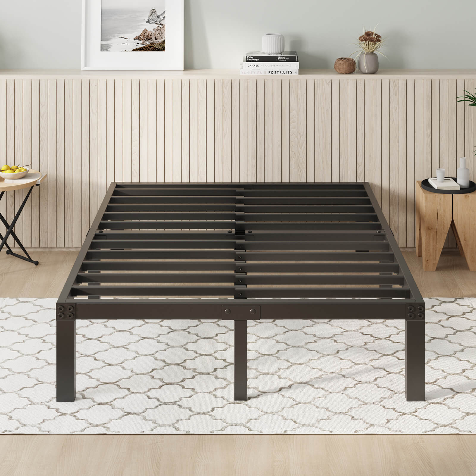 A dark metal platform bed frame with slats on a patterned rug in a modern bedroom. No headboard or mattress is shown