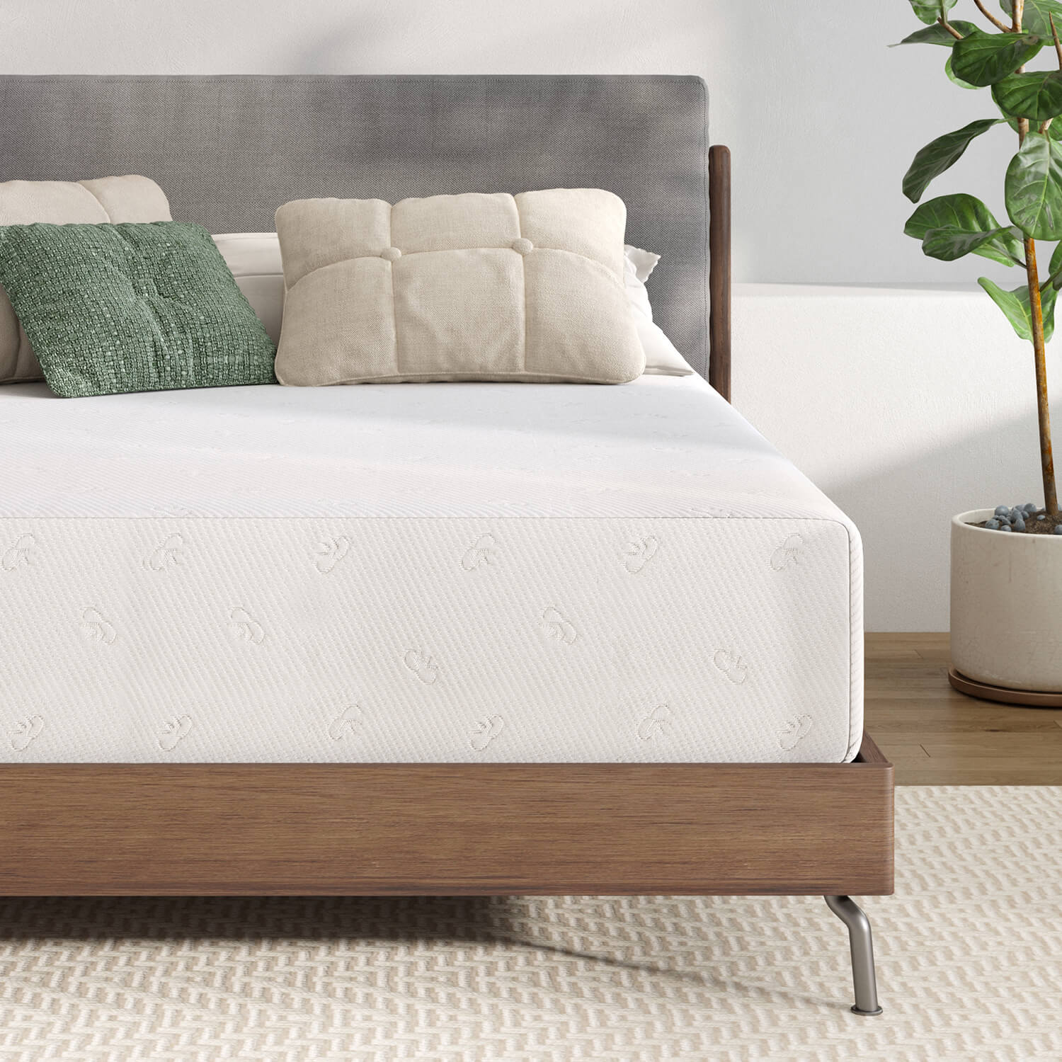 Quietude memory foam mattress with embossed pattern, pillows, and plant in a bedroom setting.