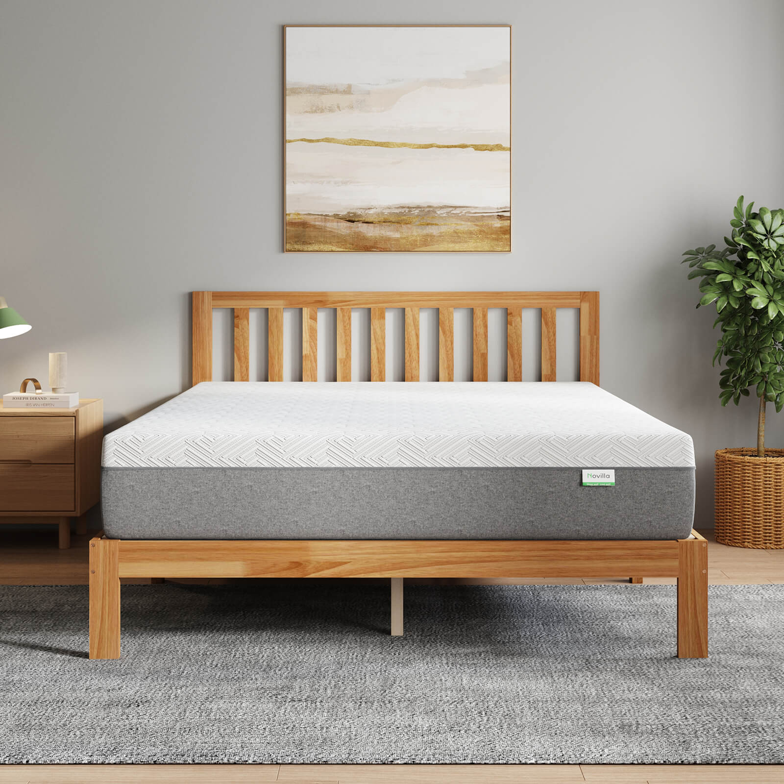 Bliss Classic Bundle white and gray mattress on a light wood bed frame in a modern bedroom with abstract art and a plant.