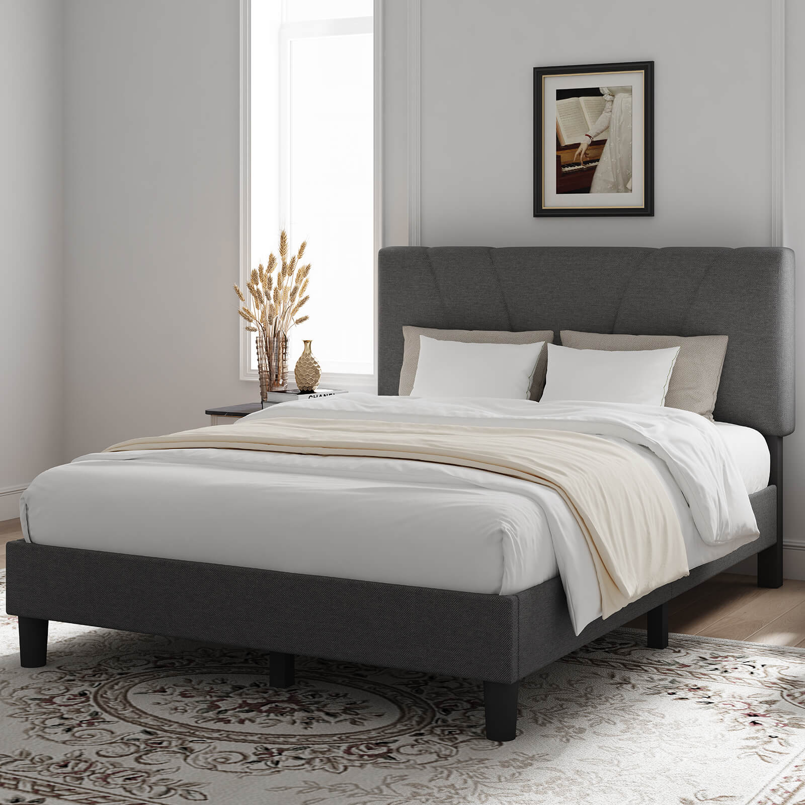 Dark gray upholstered bed frame with adjustable V-stitched headboard and white bedding in a bedroom.