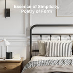 Black Vibe metal bed frame with curved headboard, vertical spindles, houndstooth throw, striped pillows.