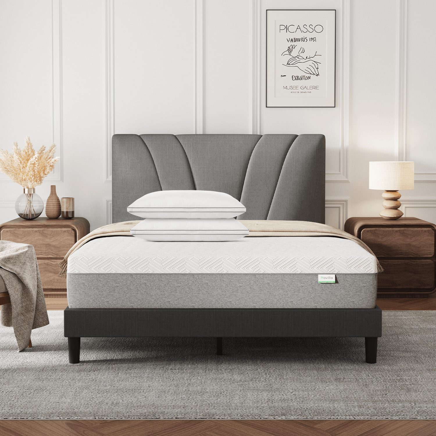Bliss Adjustable Sleep Bundle: Mattress & pillows on a gray upholstered bed in a modern bedroom setting.