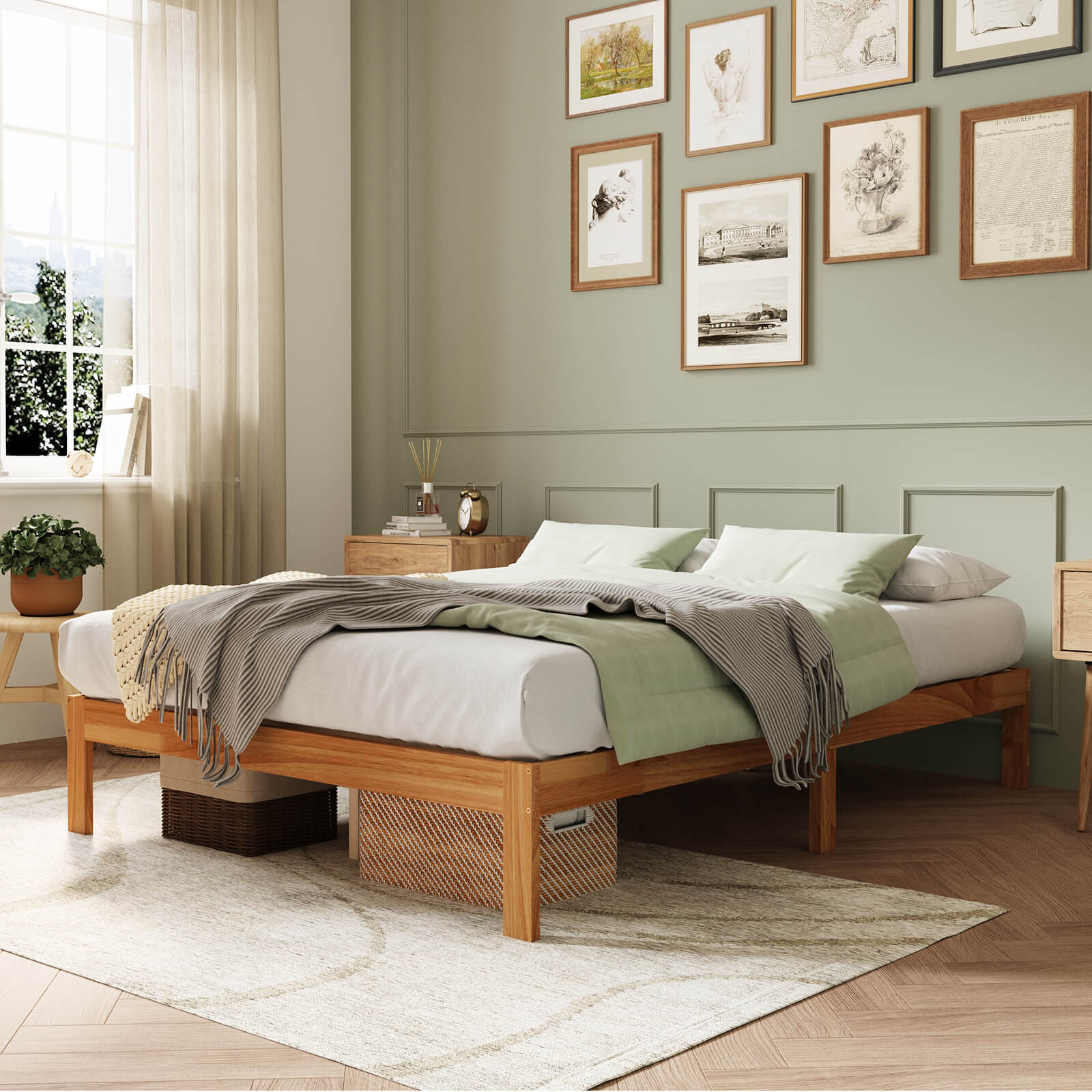 Natural wood bed frame with white and green bedding, under-bed storage baskets, sage green walls, and gallery wall.