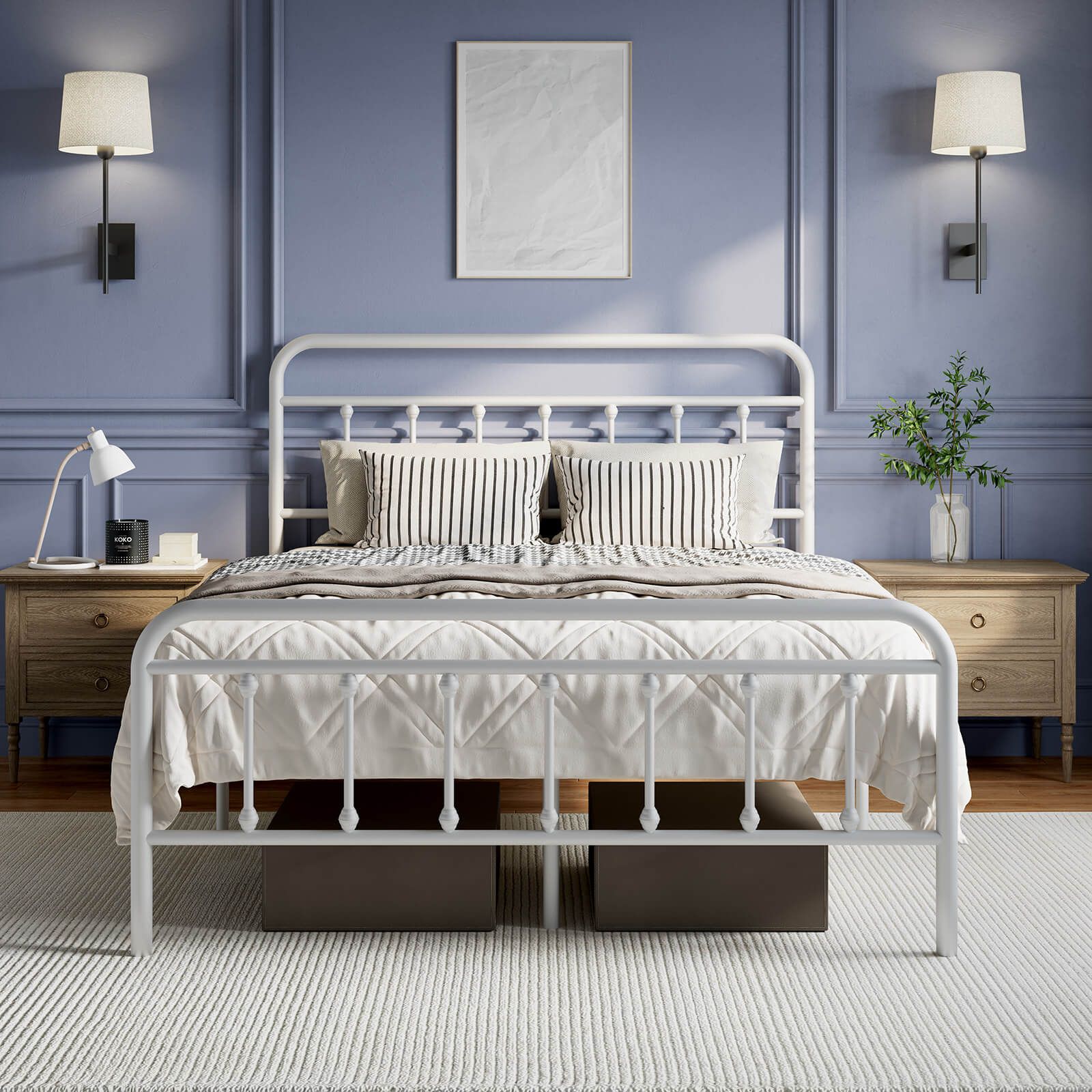 White Vibe metal bed frame with rounded headboard, vertical spindles, and striped pillows on quilted bedding.